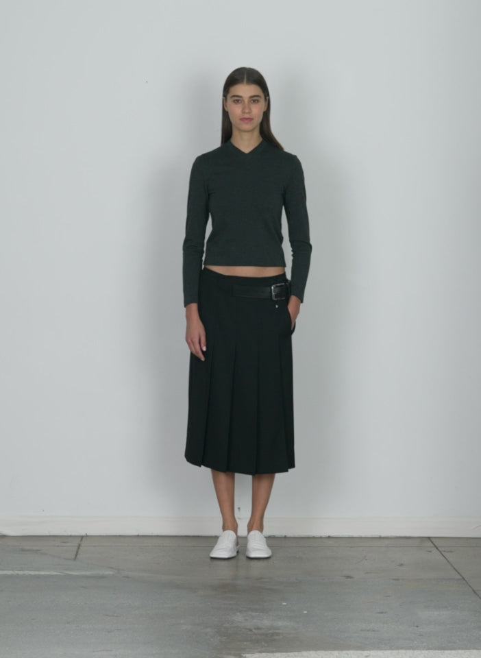 Model wearing the grain de poudre wide pleat wrap skirt black walking forward and turning around