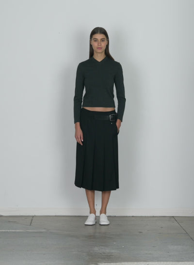 Model wearing the grain de poudre wide pleat wrap skirt black walking forward and turning around