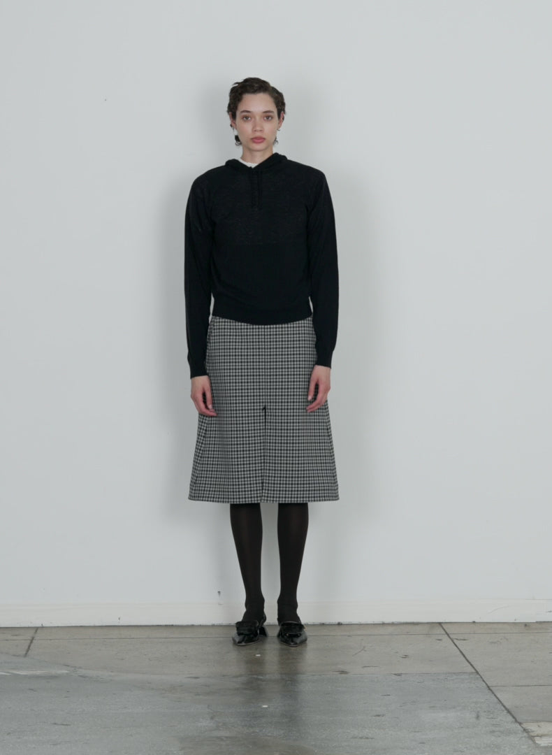 Model wearing the double faced menswear check aline skirt black grey multi walking forward and turning around