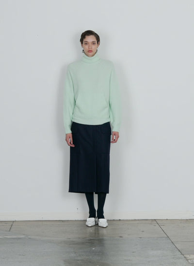 Model wearing the douillet tneck easy pullover pale mint walking forward and turning around