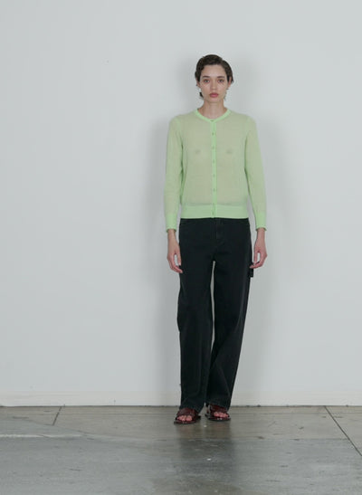 Model wearing the skinlike mercerized wool shrunken cardigan pale lime walking forward and turning around