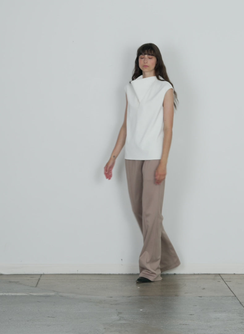Model wearing the chalky drape handkerchief top white walking forward and turning around