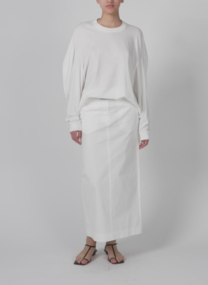Model wearing the tshirt circular top white walking forward and turning around