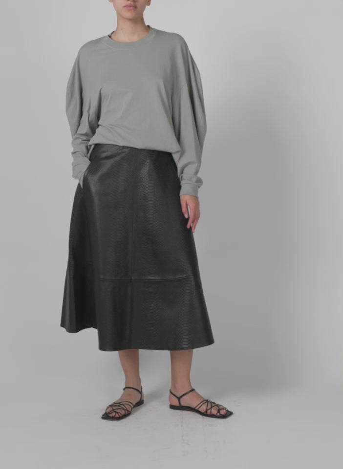 Model wearing the tshirt circular top pumice grey walking forward and turning around