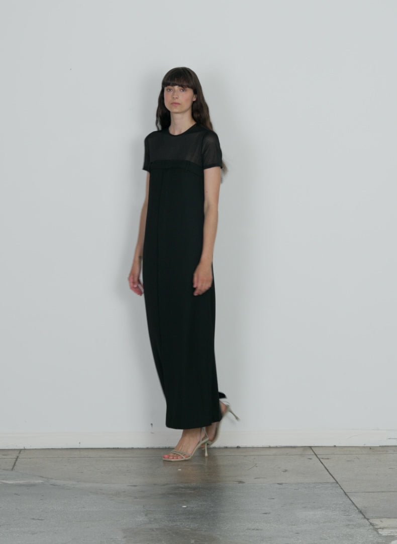 Model wearing the salopette long dress black walking forward and turning around