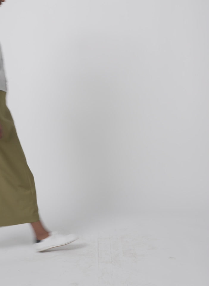 Model wearing the tropical wool maxi trouser skirt dark hazel walking forward and turning around
