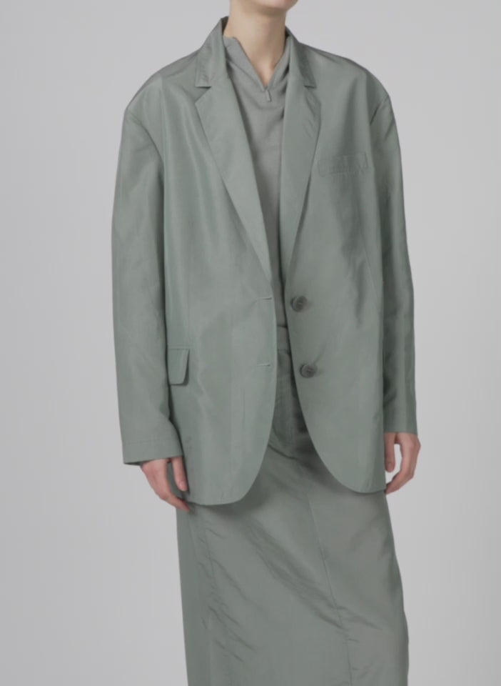 Model wearing the silk nylon liam blazer pumice grey walking forward and turning around