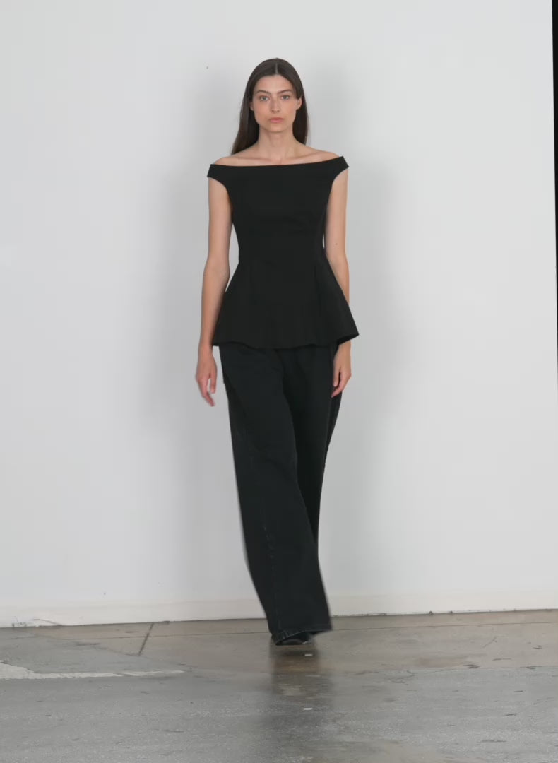 Model wearing the schema sculpted top black walking forward and turning around