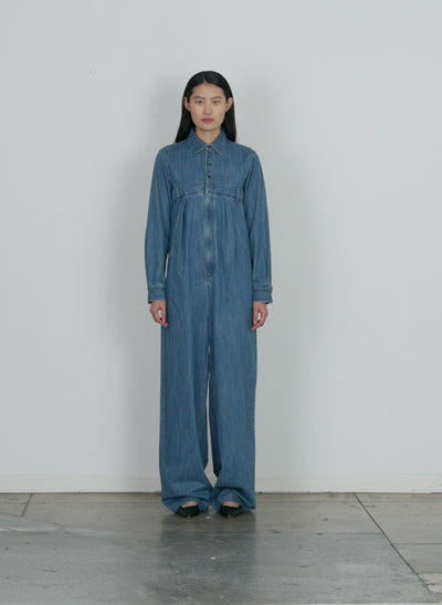 Model wearing the lightweight stone washed denim jumpsuit denim blue walking forward and turning around