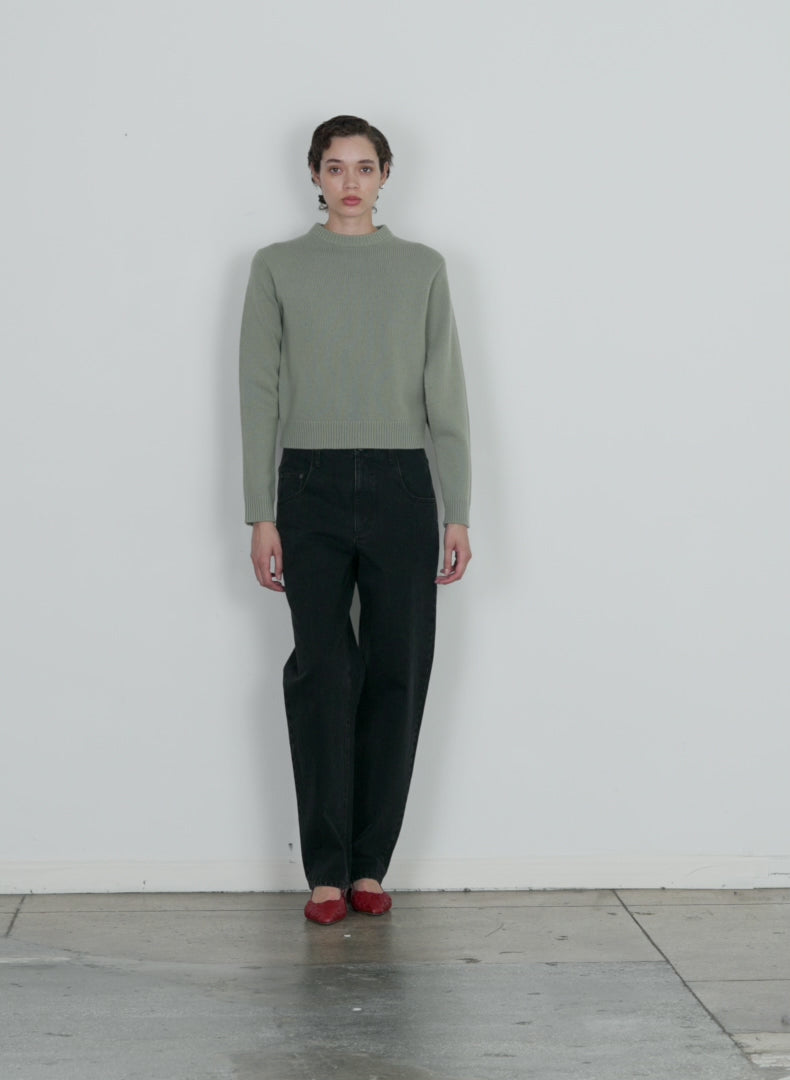 Model wearing the soft lambswool shrunken crewneck pullover pale olive walking forward and turning around