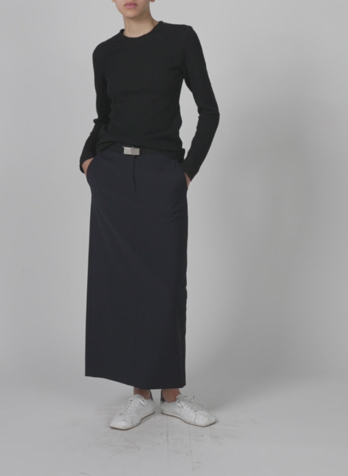 Model wearing the boucle knit long sleeve circular top black walking forward and turning around