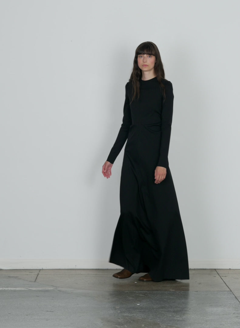 Model wearing the compact ultra stretch knit lean maxi gown black walking forward and turning around