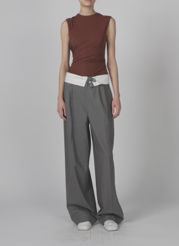 Model wearing the tencel knit twisted seam tank brown walking forward and turning around