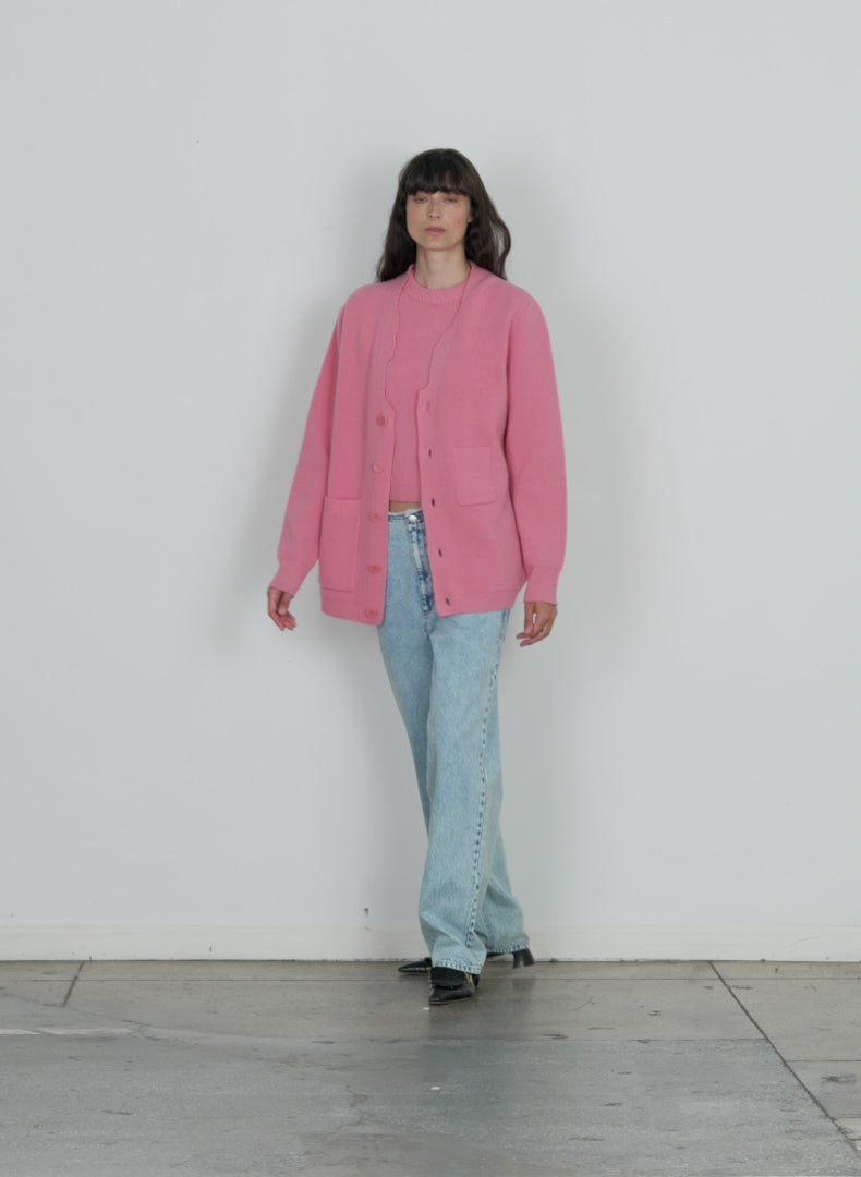 Model wearing the soft lambswool distressed cardigan pink walking forward and turning around