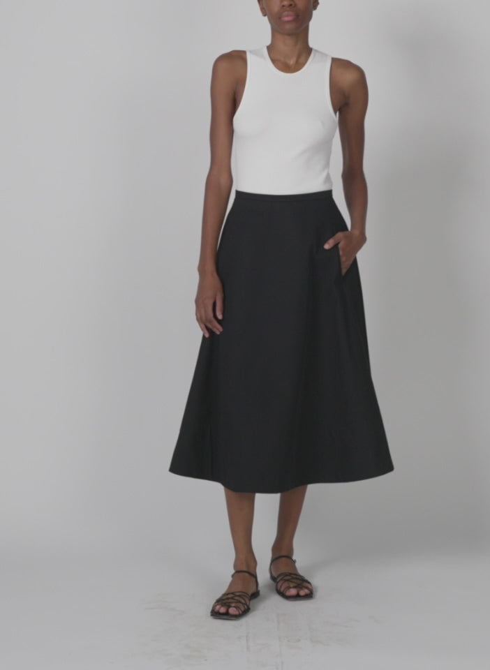 Model wearing the bonded luxe twill circle skirt black walking forward and turning around