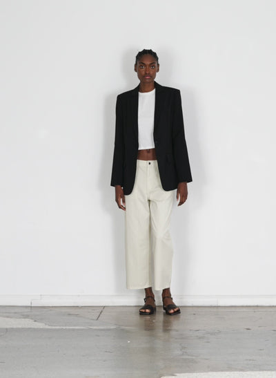 Model wearing the garment dyed twill cropped slouchy carpenter jean cream walking forward and turning around