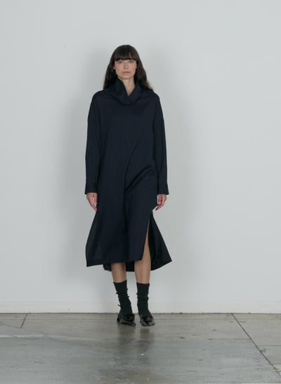 Model wearing the lyocell drape cowl neck dress navy multi walking forward and turning around