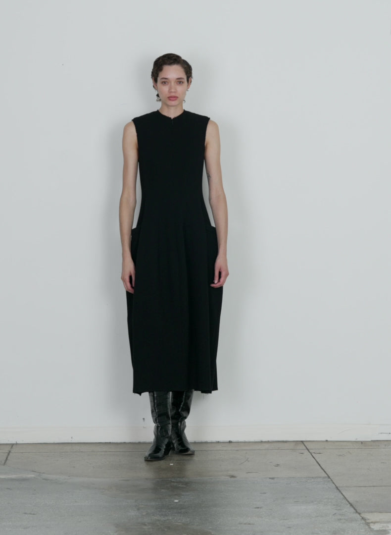 Model wearing the melee crepe dress black walking forward and turning around