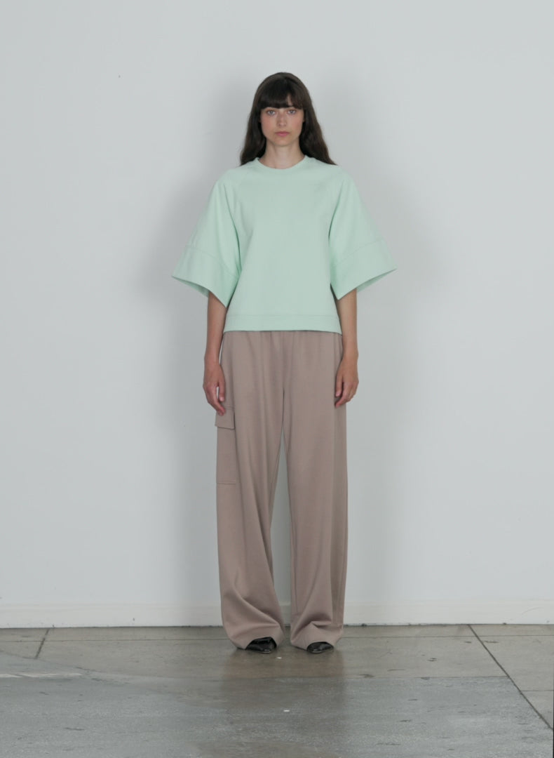 Model wearing the active knit wide leg pullon pant khaki walking forward and turning around