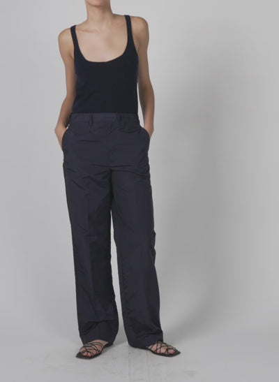 Model wearing the silk nylon straight leg trouser navy walking forward and turning around