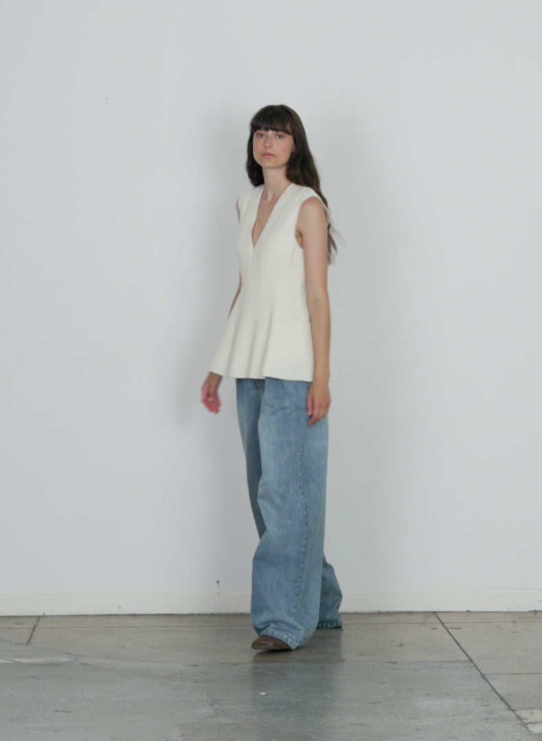 Model wearing the melee crepe vneck top ivory walking forward and turning around