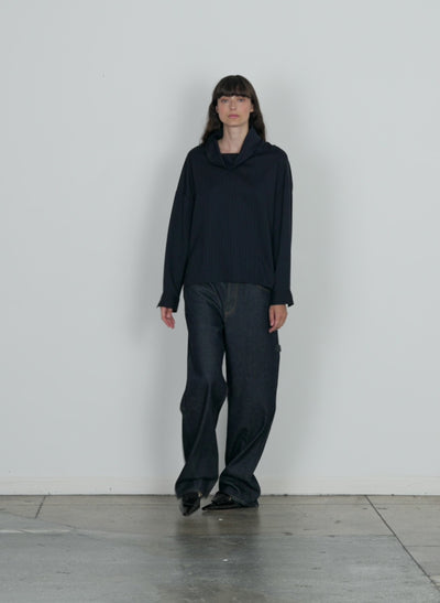 Model wearing the lyocell drape cowl neck top navy multi walking forward and turning around