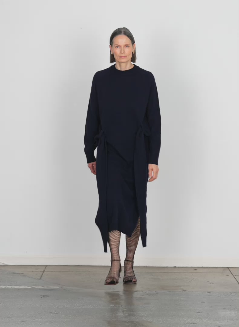 Model wearing the airy extrafine wool blair dress navy walking forward and turning around