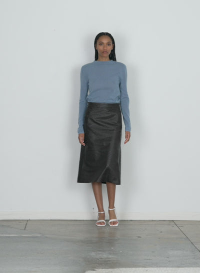 Model wearing the ostrich leather a-line skirt dark brown walking forward and turning around