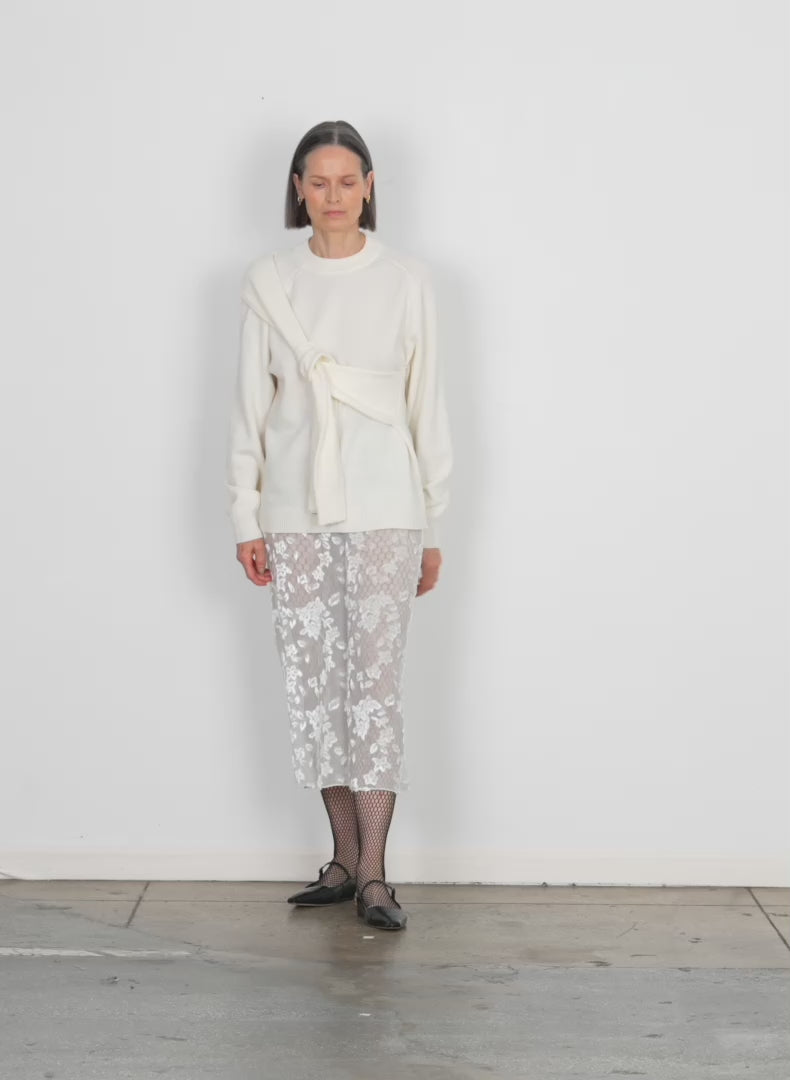 Model wearing the ione velvet burnout slip skirt winter white walking forward and turning around