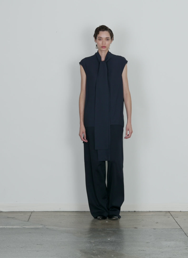 Model wearing the feather weight eco crepe sleeveless davenport scul midnight navy walking forward and turning around