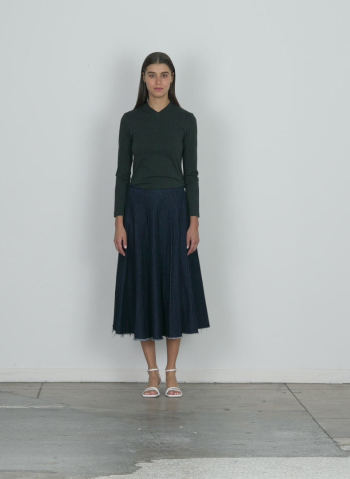 Model wearing the brushed denim pintucked skirt indigo walking forward and turning around