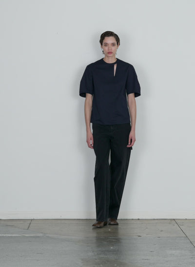 Model wearing the eco poplin sculpted sleeve top with cut out detail dark navy walking forward and turning around