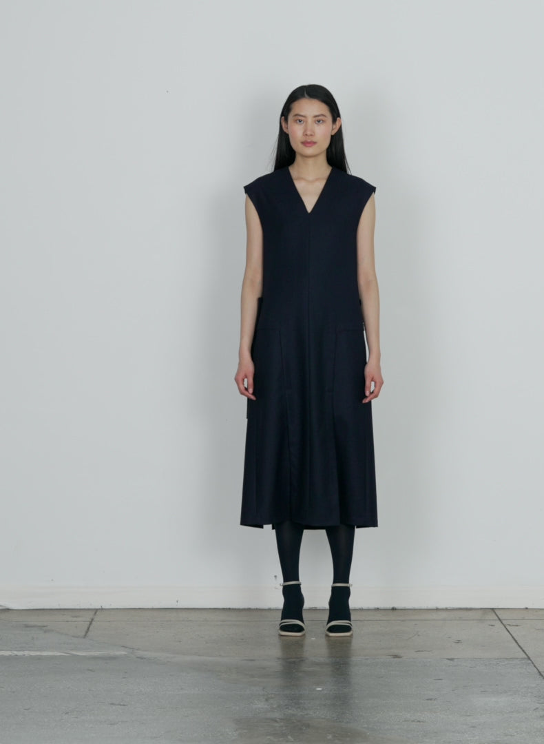 Model wearing the superfine wool flannel paneled dress navy walking forward and turning around