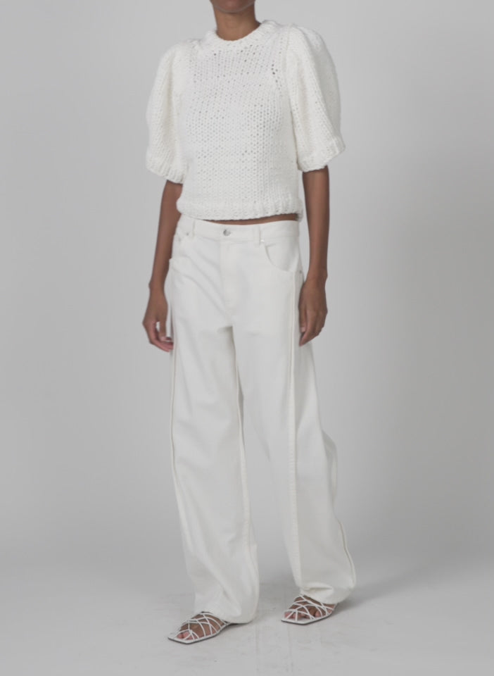Model wearing the spring denim tuck jean white walking forward and turning around