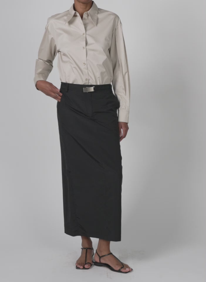 Model wearing the silk nylon maxi skirt black walking forward and turning around