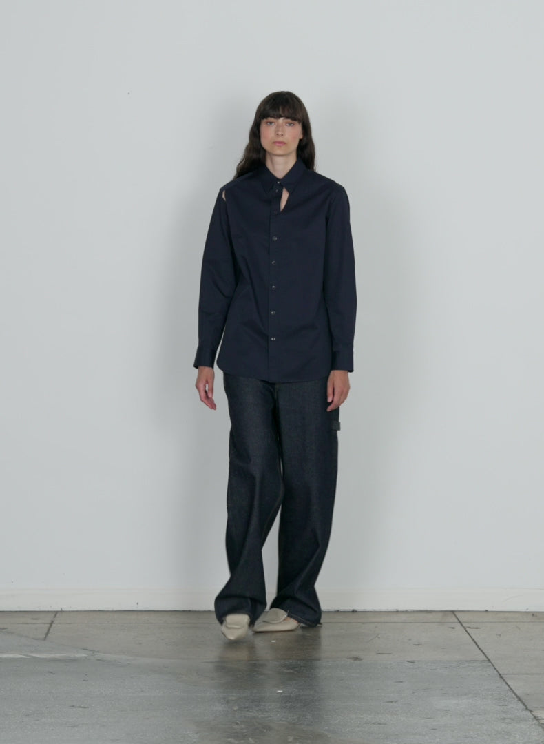 Model wearing the eco poplin cut out charlie shirt dark navy walking forward and turning around