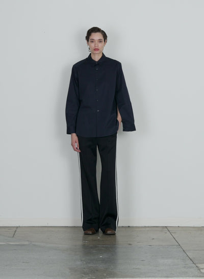 Model wearing the eco poplin shirt with inseam vent dark navy walking forward and turning around