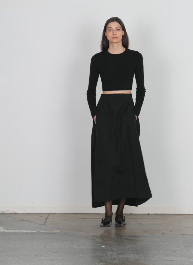 Model wearing the schema sculpted midi skirt black walking forward and turning around