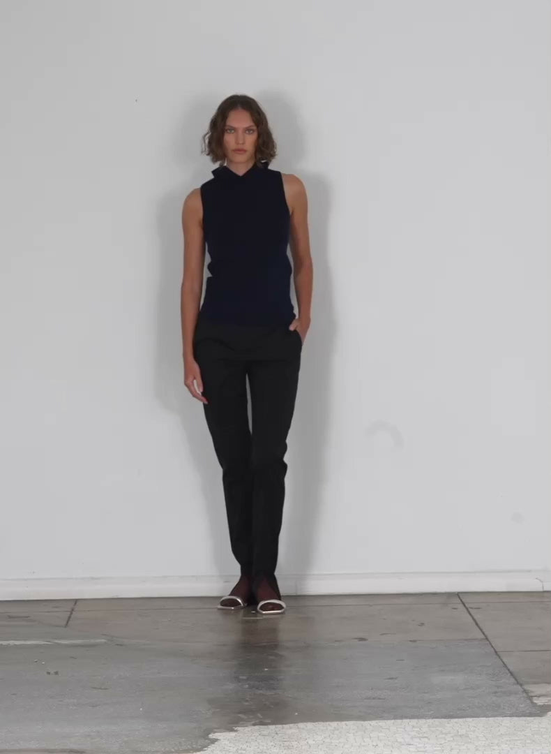Model wearing the cassius suiting slim pant with front slit detail black walking forward and turning around