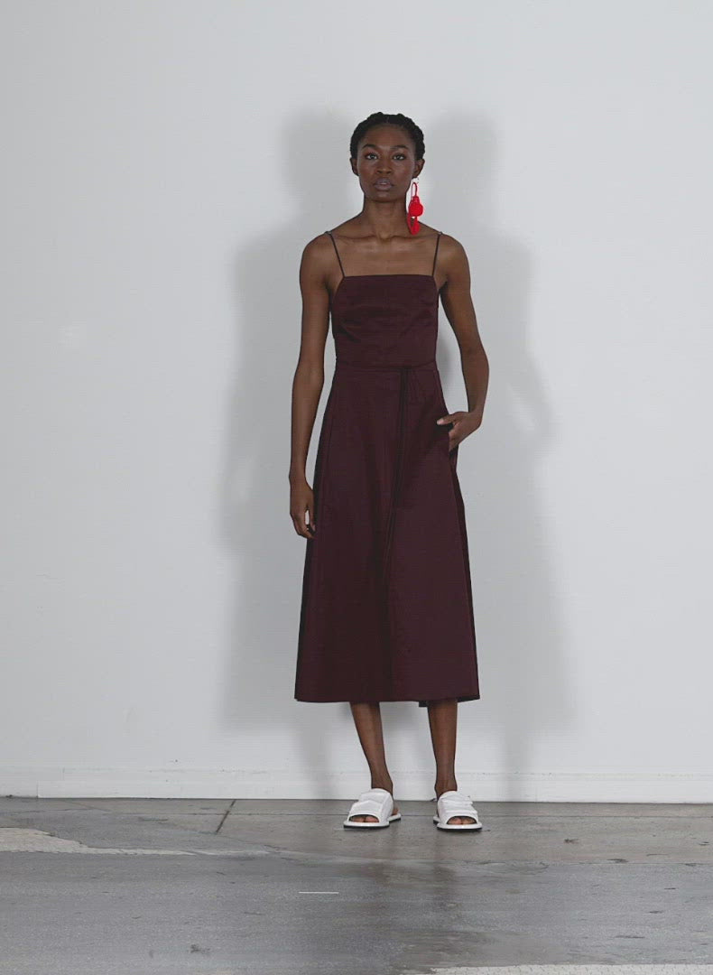 Model wearing the eco poplin strappy dress brown walking forward and turning around