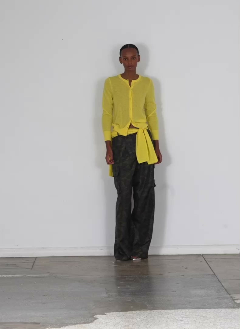 Model wearing the skinlike mercerized wool shrunken cardigan yellow walking forward and turning around