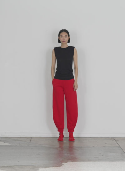 Model wearing the calder sweatpant red walking forward and turning around