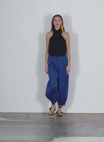 Model wearing the eco poplin halter top dark navy walking forward and turning around