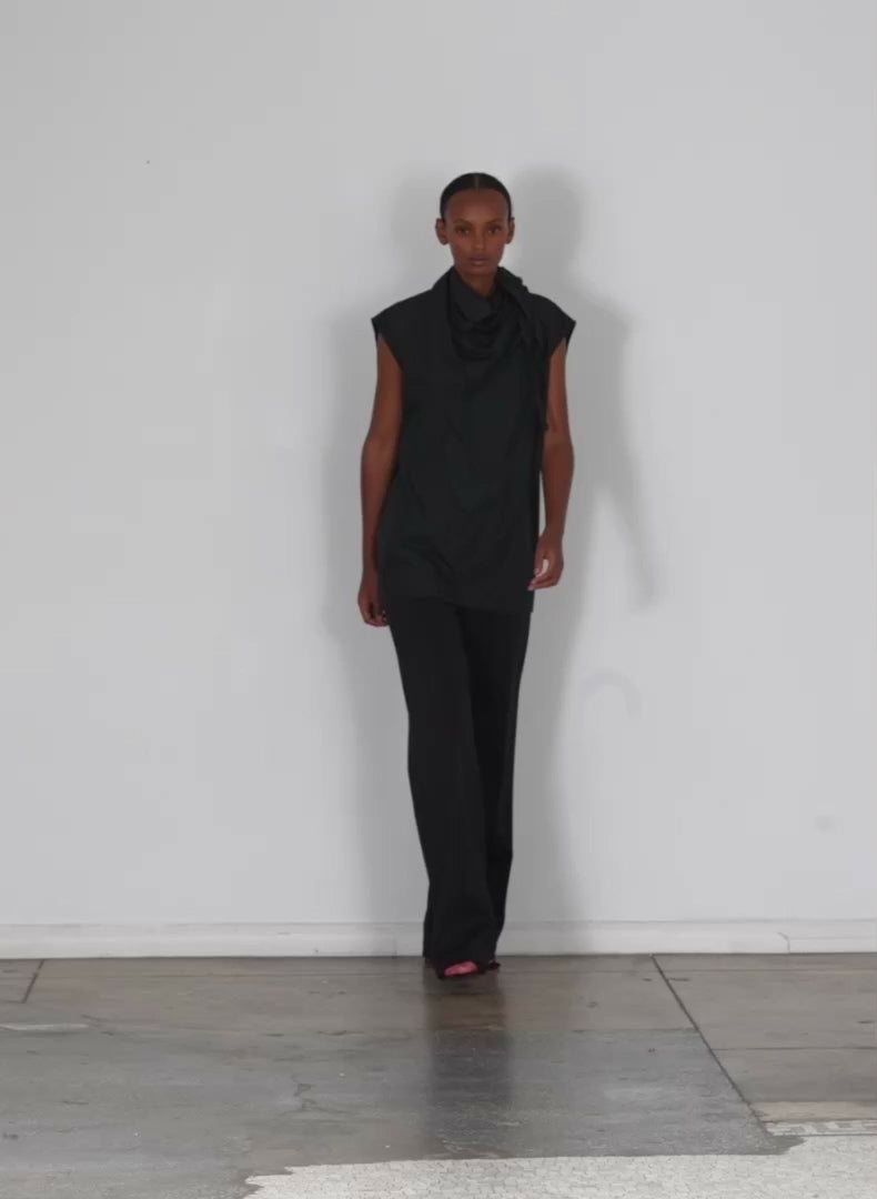 Model wearing the italian sporty nylon sleeveless cocoon top black walking forward and turning around