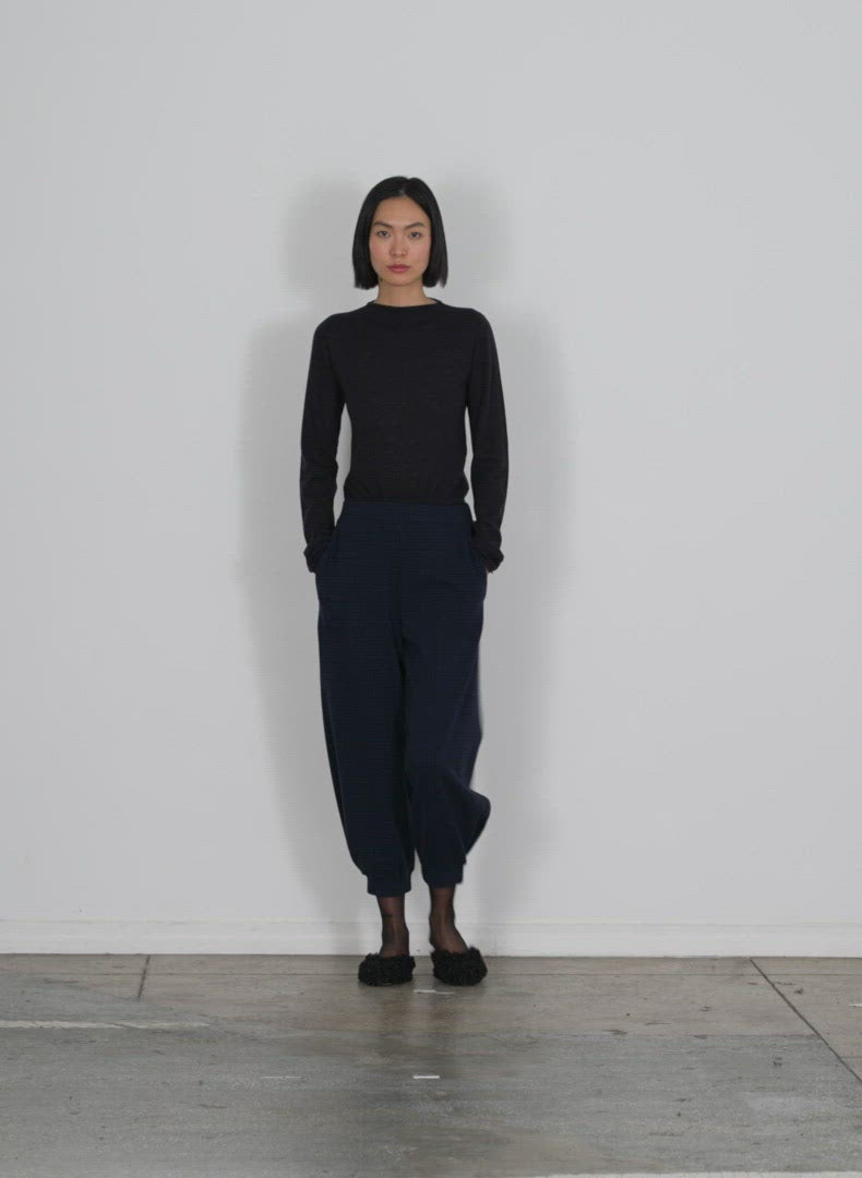 Model wearing the camille check kat sculpted pull on pant long inse black navy multi walking forward and turning around