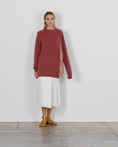 Model wearing the f w cashmere cutout sleeve tunic pullover walking forward and turning around