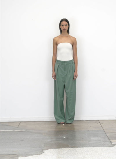 Model wearing the tropical wool stella pant dark mint walking forward and turning around