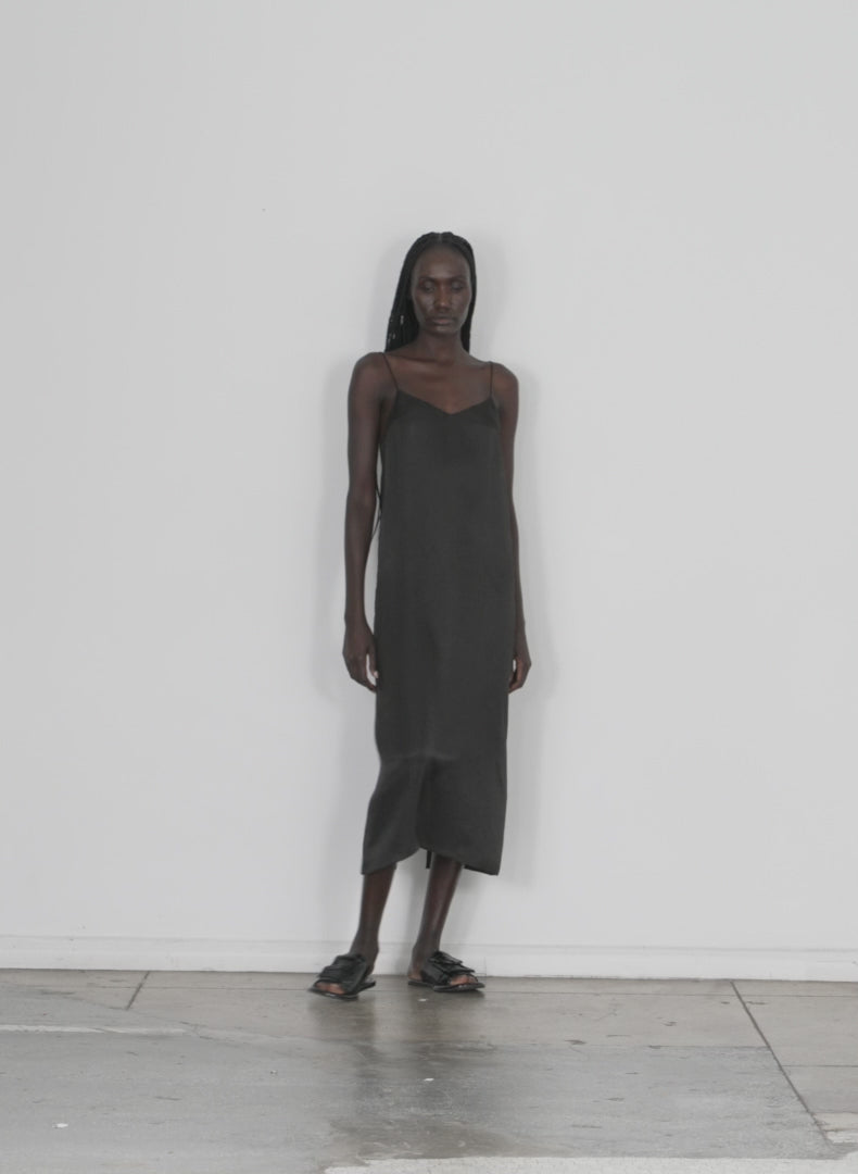 Model wearing the the slip dress black walking forward and turning around