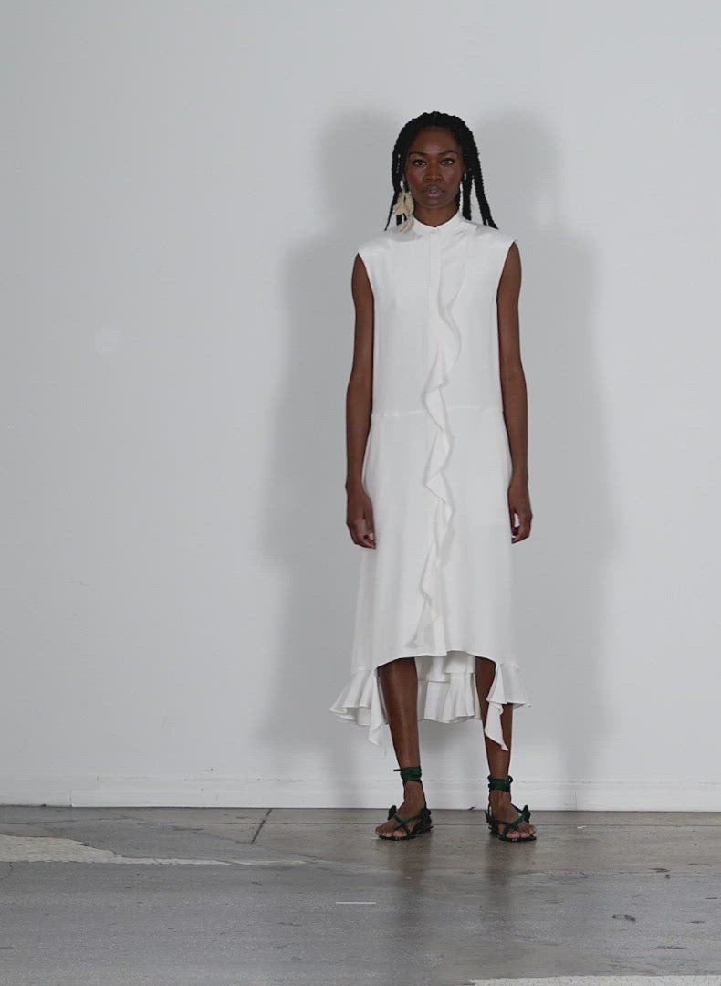 Model wearing the 4ply silk detached ruffle shirtdress white walking forward and turning around