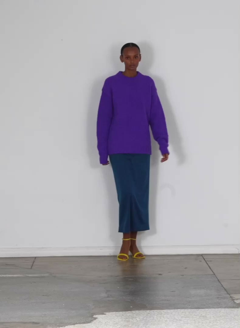 Model wearing the airy alpaca crewneck pullover purple walking forward and turning around